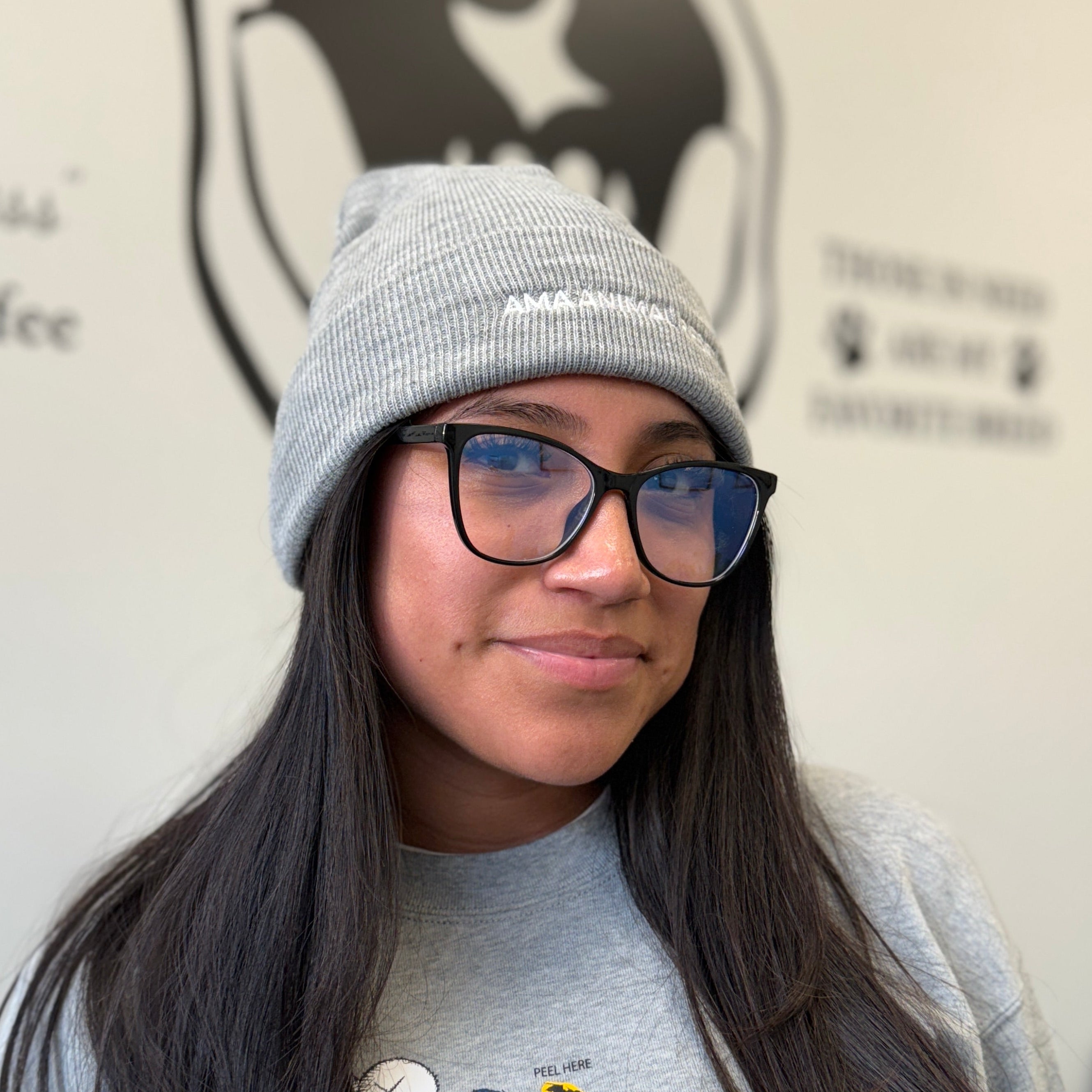 Person wearing a gray beanie and gray shirt with a AMA Animal rescue logo